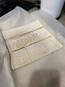 raw puff pastry cut into nine squares on parchment-lined baking sheet